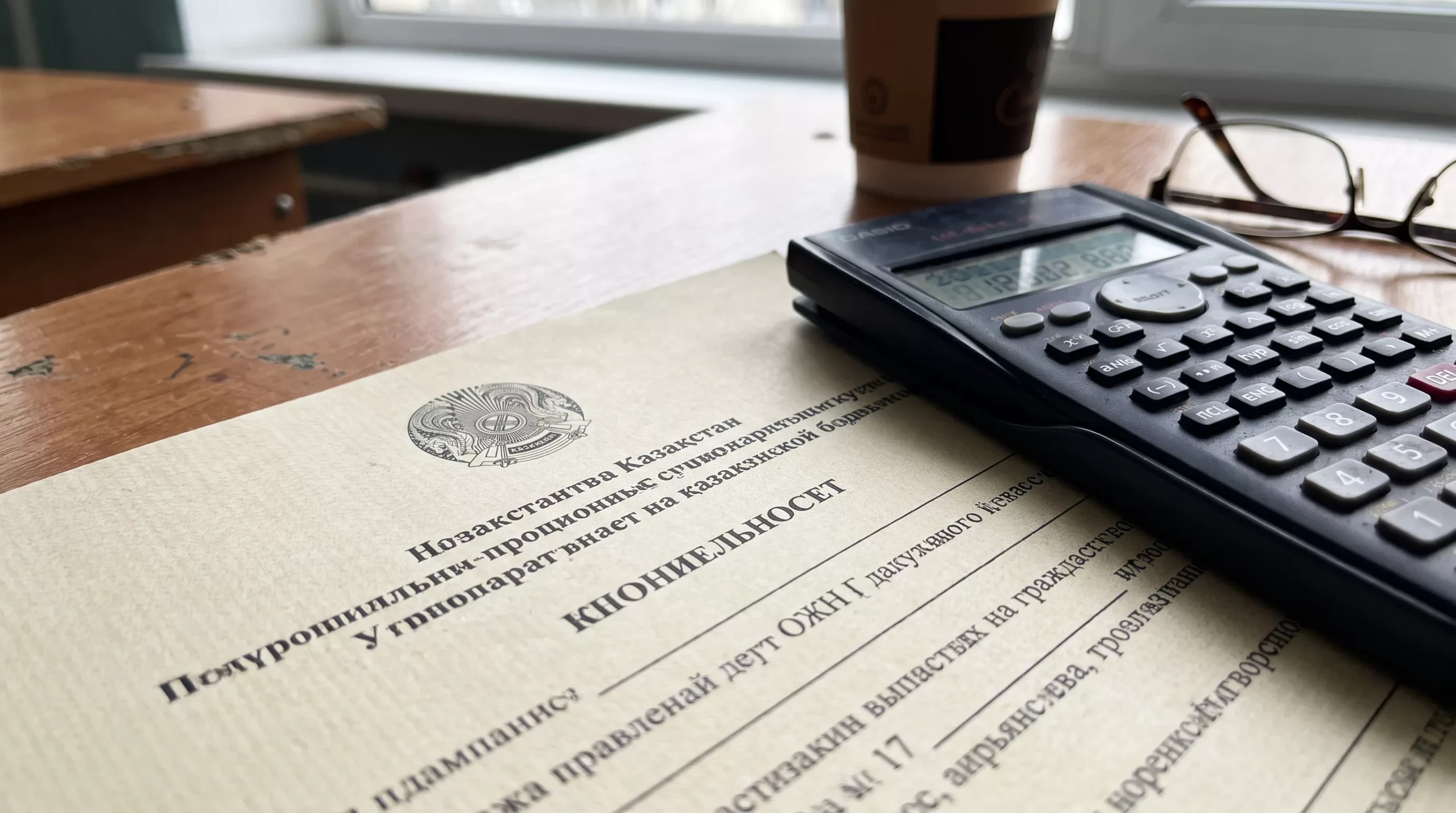Уведомление о налоге на имущество на столе рядом с калькулятором